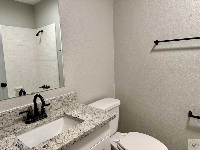 bathroom with a shower, toilet, and vanity