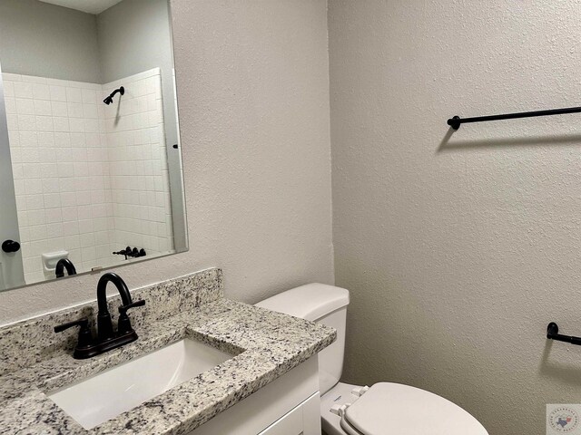 bathroom with a shower, toilet, and vanity