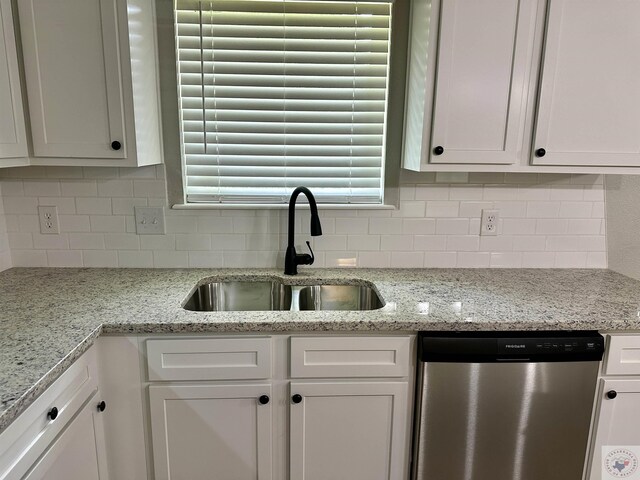 kitchen with white cabinets, decorative backsplash, sink, light stone counters, and stainless steel dishwasher