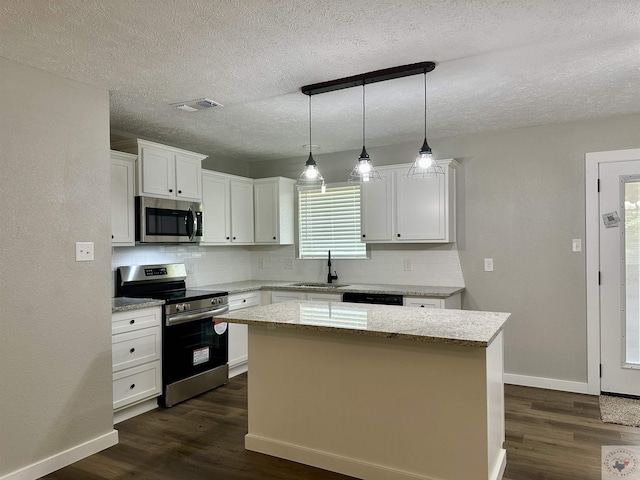 kitchen featuring pendant lighting, white cabinets, appliances with stainless steel finishes, a center island, and sink