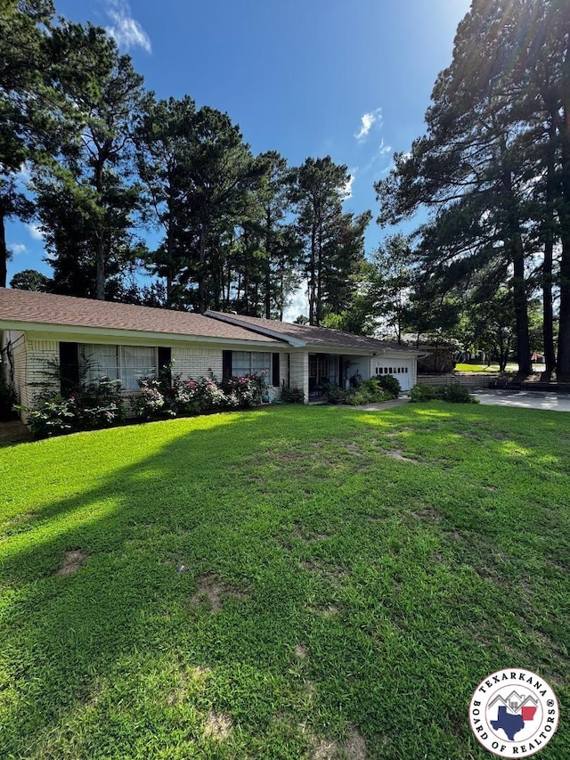 1509 W 40th St, Texarkana, TX 75503 - ranch-style house with an attached garage and a front lawn