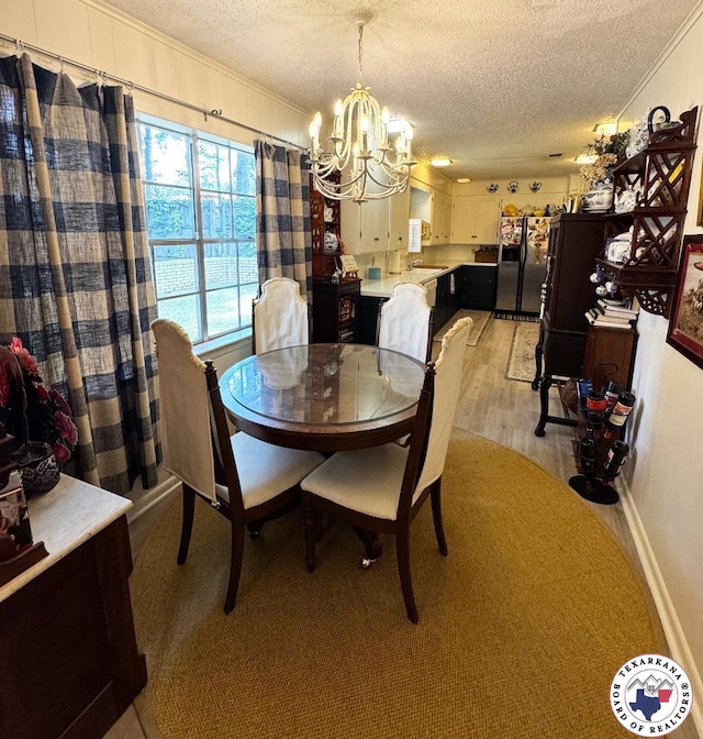 1509 W 40th St, Texarkana, TX 75503 - dining area featuring a textured ceiling, a chandelier, crown molding, and light wood-style floors