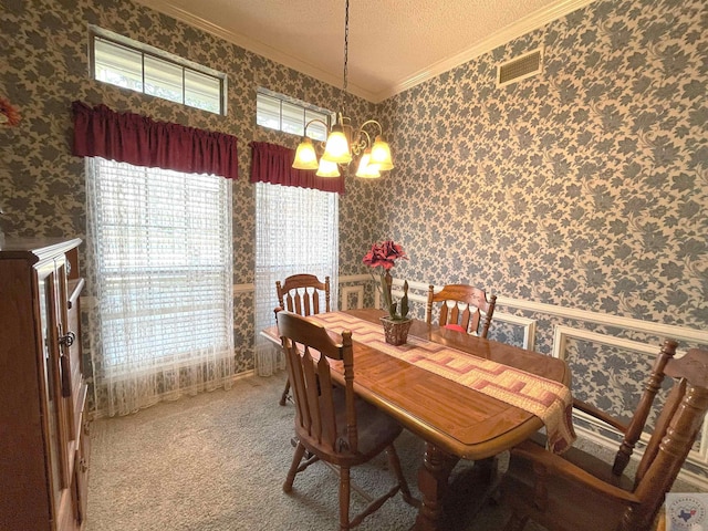 dining room featuring ornamental molding, a chandelier, and carpet floors