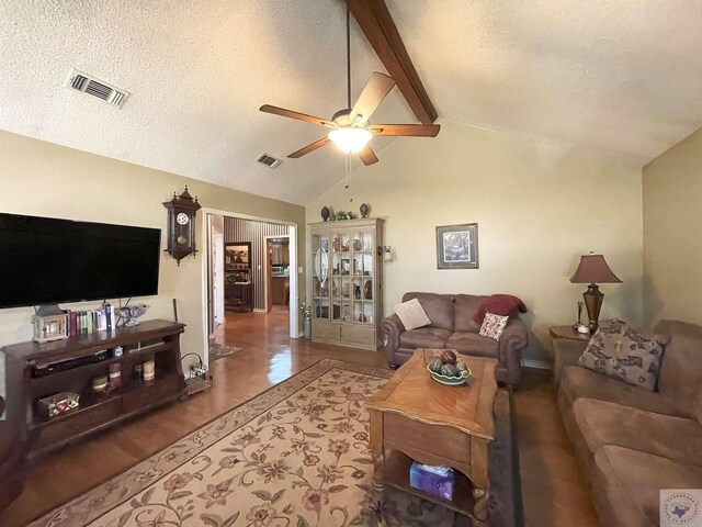 living room featuring ceiling fan, high vaulted ceiling, a textured ceiling, and beam ceiling