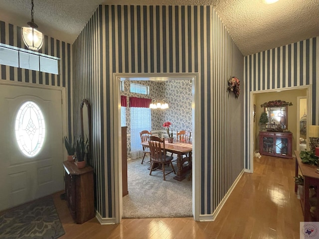 foyer featuring a notable chandelier, a textured ceiling, and wood-type flooring