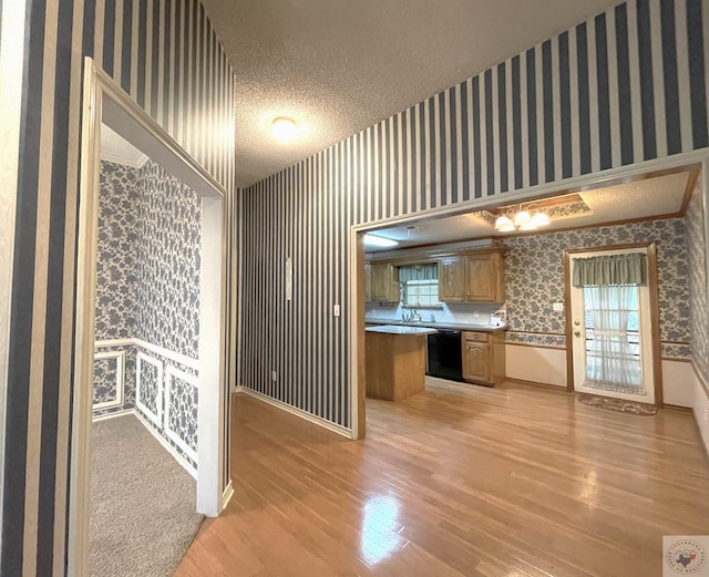 130 Westline Rd, Wake Village, TX 75501 - kitchen with wallpapered walls, dishwasher, light wood-style floors, a textured ceiling, and a wainscoted wall