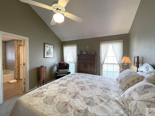 bedroom featuring vaulted ceiling, ensuite bath, carpet flooring, ceiling fan, and a textured ceiling