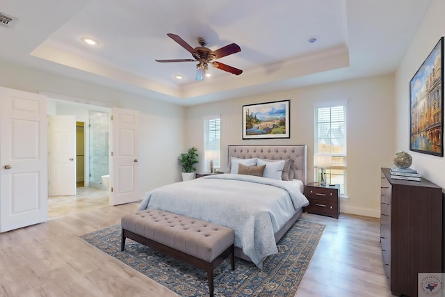 bedroom with multiple windows, ceiling fan, and a raised ceiling