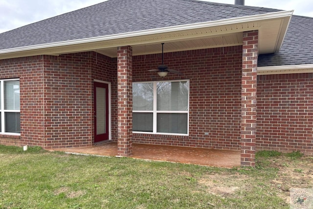 entrance to property with ceiling fan and a lawn