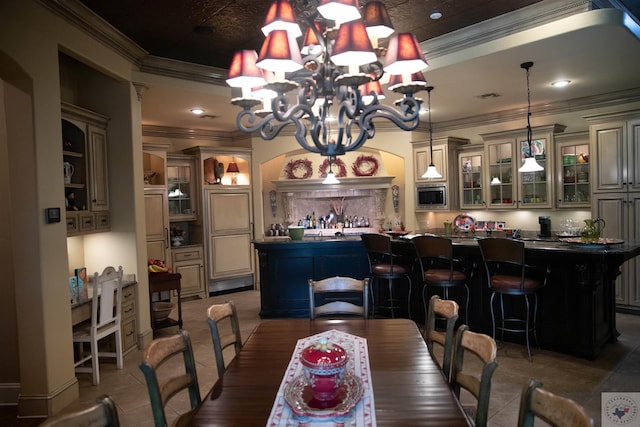 dining space featuring dark tile patterned flooring, ornamental molding, and an inviting chandelier