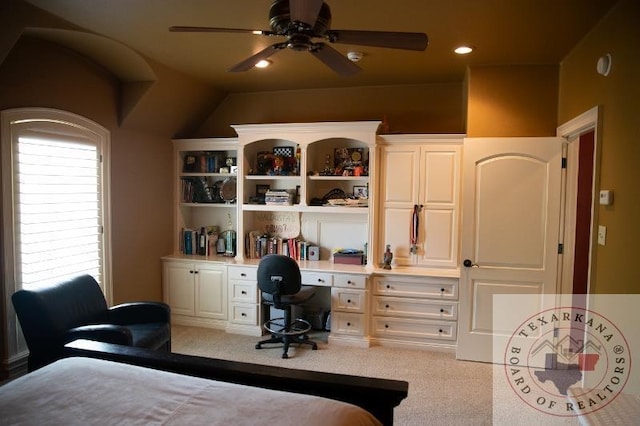 bedroom with lofted ceiling, light carpet, and built in desk