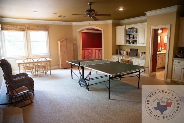 recreation room featuring light carpet, ceiling fan, and ornamental molding