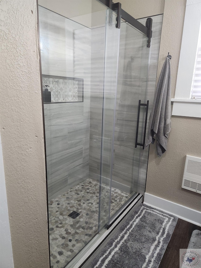 bathroom with hardwood / wood-style flooring and walk in shower