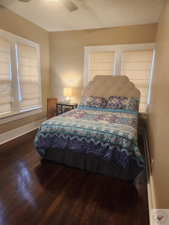 bedroom with ceiling fan, hardwood / wood-style floors, and a textured ceiling