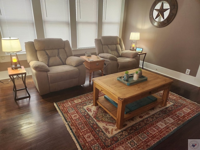 living room featuring a wealth of natural light and dark wood-type flooring