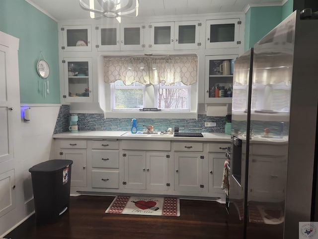 kitchen with dark wood-type flooring, sink, white cabinetry, stainless steel fridge, and backsplash