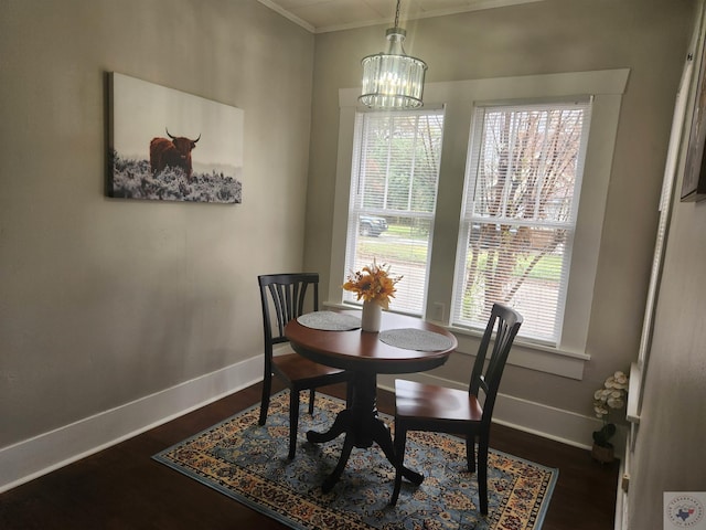 dining space with ornamental molding, plenty of natural light, dark wood-type flooring, and a chandelier