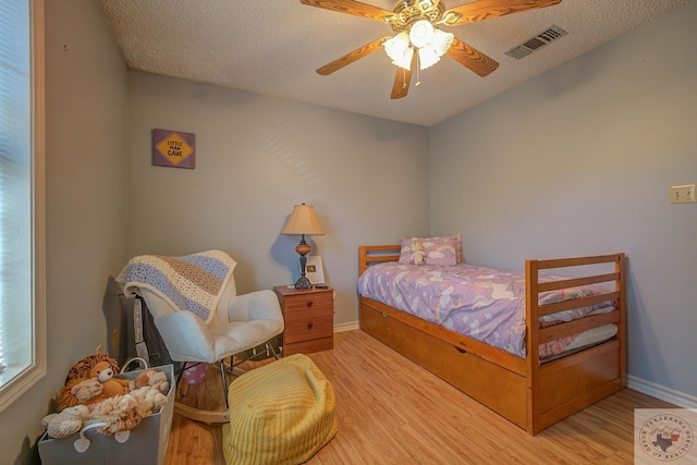 bedroom featuring hardwood / wood-style floors, a textured ceiling, and ceiling fan