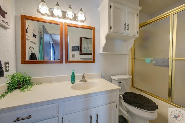 full bathroom featuring vanity, shower / bath combination with glass door, and toilet