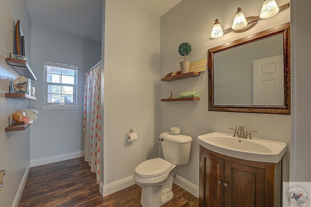 bathroom featuring a shower with curtain, hardwood / wood-style flooring, toilet, and vanity