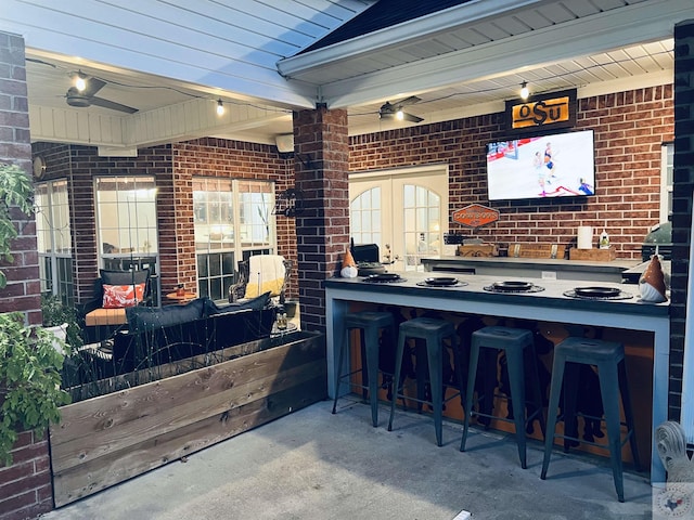 bar featuring beamed ceiling, brick wall, and french doors