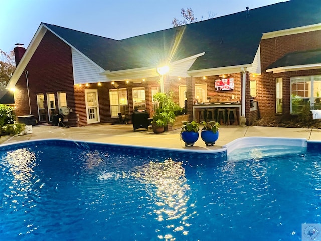 view of pool with a bar and a patio