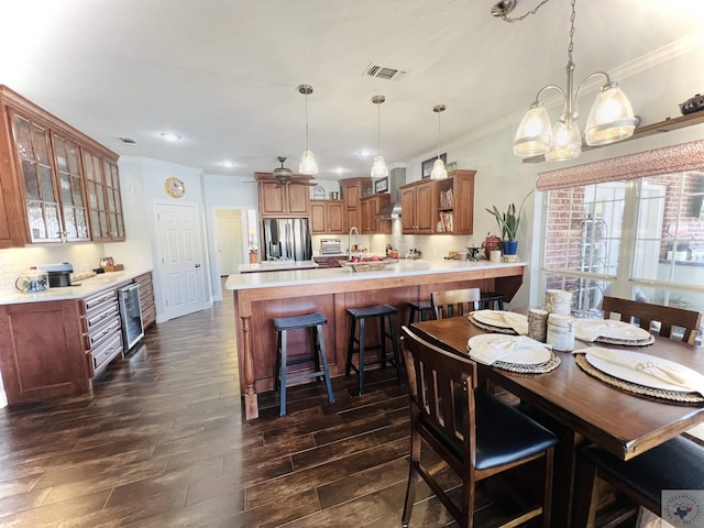 dining area with dark hardwood / wood-style flooring, wine cooler, sink, ceiling fan, and crown molding