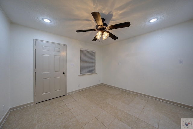 tiled spare room featuring ceiling fan and a textured ceiling