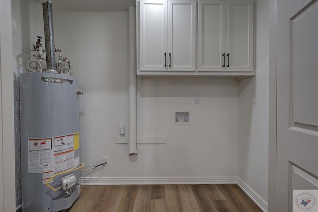 washroom with washer hookup, wood-type flooring, cabinets, and water heater