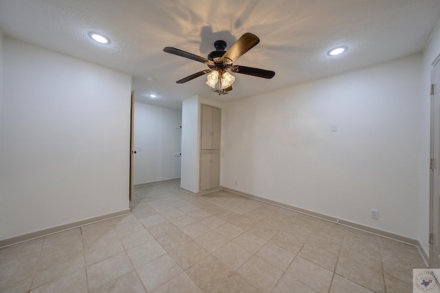 tiled spare room with ceiling fan and a textured ceiling