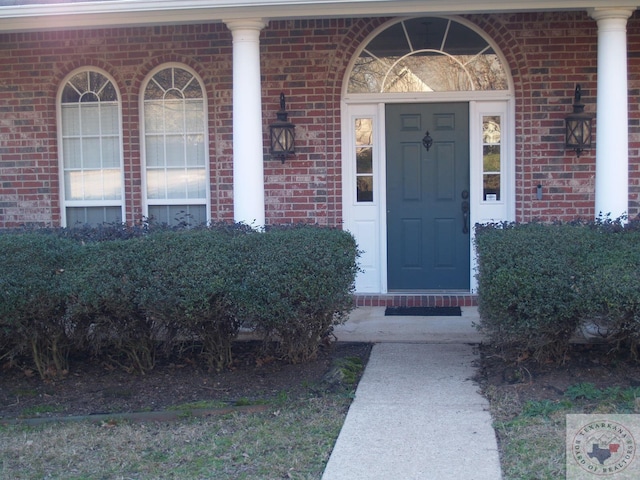 view of exterior entry with brick siding