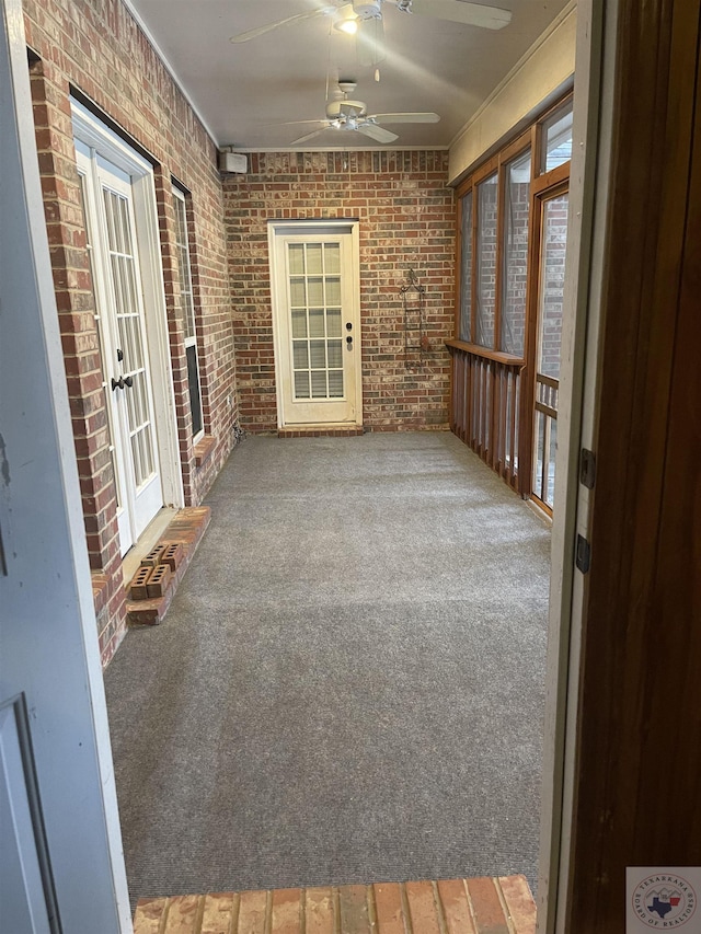 7311 Shilling Cir, Texarkana, TX 75503 - unfurnished sunroom featuring a ceiling fan, brick wall, french doors, and carpet flooring