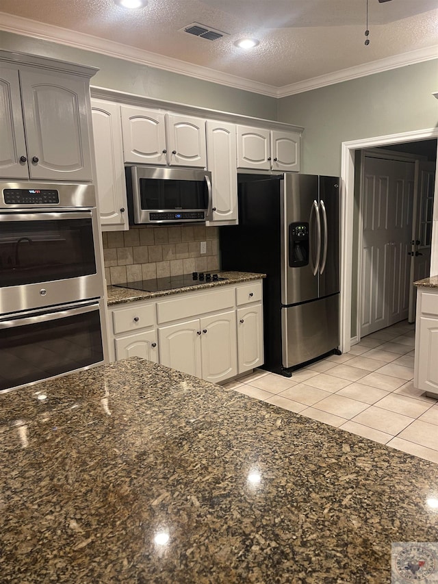 7311 Shilling Cir, Texarkana, TX 75503 - kitchen with appliances with stainless steel finishes, backsplash, dark stone counters, white cabinets, and ornamental molding