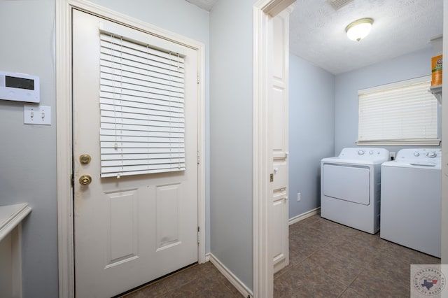 laundry area with washing machine and clothes dryer and a textured ceiling