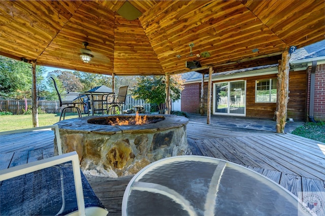 wooden terrace featuring an outdoor fire pit and a gazebo