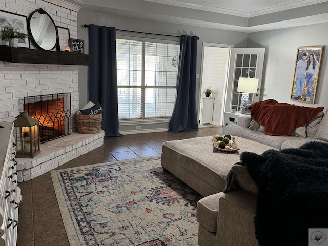 living room with ornamental molding, a brick fireplace, and dark tile patterned floors