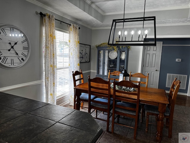 tiled dining area with crown molding and a textured ceiling