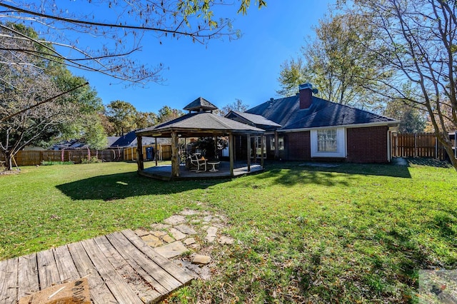 rear view of property with a gazebo and a yard