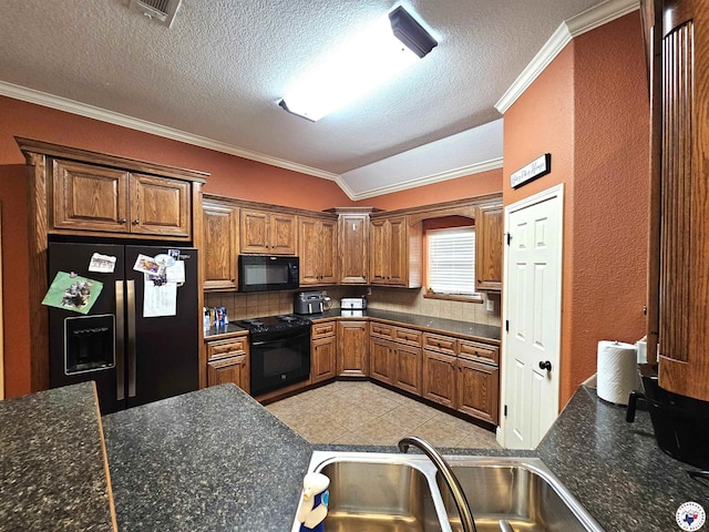 kitchen with crown molding, brown cabinets, visible vents, vaulted ceiling, and black appliances