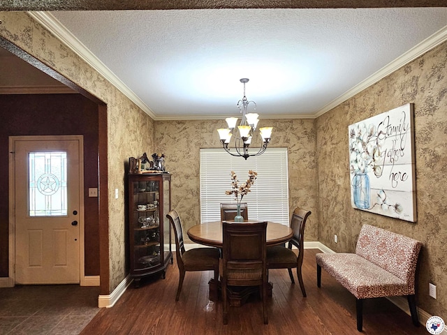 dining room with crown molding, baseboards, a chandelier, and wood finished floors