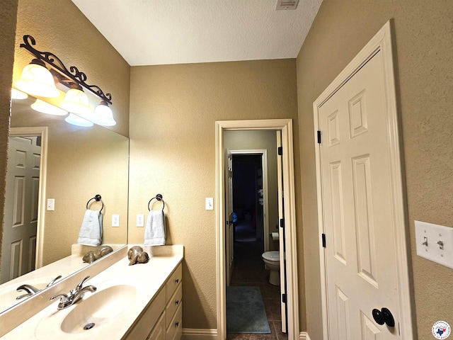 bathroom featuring a textured wall, tile patterned flooring, and vanity