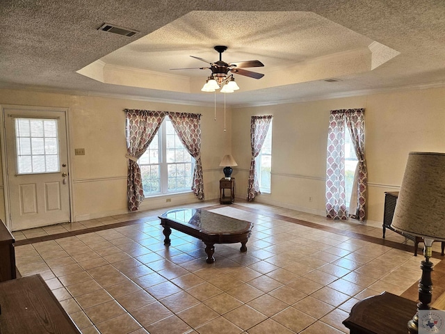 unfurnished living room with plenty of natural light, crown molding, light tile patterned floors, and a raised ceiling