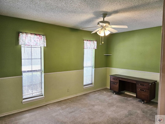 spare room with ceiling fan, light carpet, and a textured ceiling