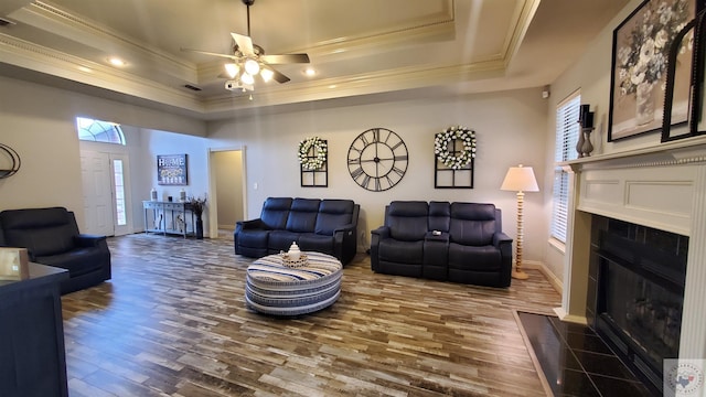 living room featuring ornamental molding, a raised ceiling, and hardwood / wood-style floors