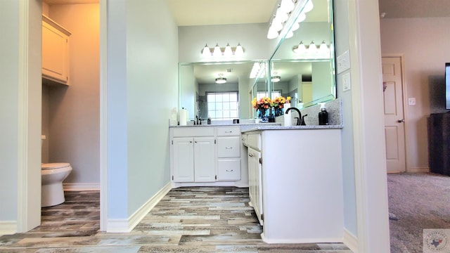 bathroom featuring vanity, hardwood / wood-style floors, and toilet