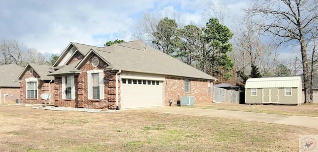 view of front facade with a garage, central AC, a shed, and a front lawn