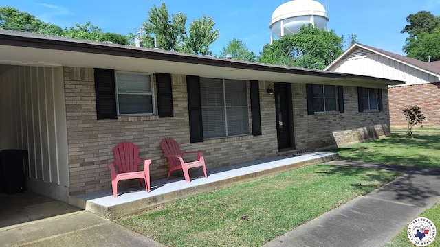 single story home with brick siding and a front yard