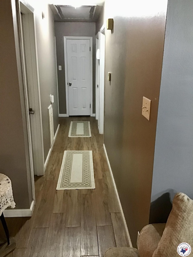 hall featuring baseboards and wood finished floors