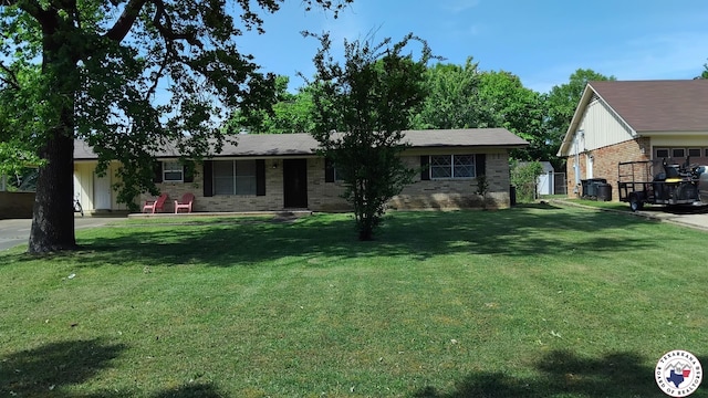 single story home with brick siding and a front yard