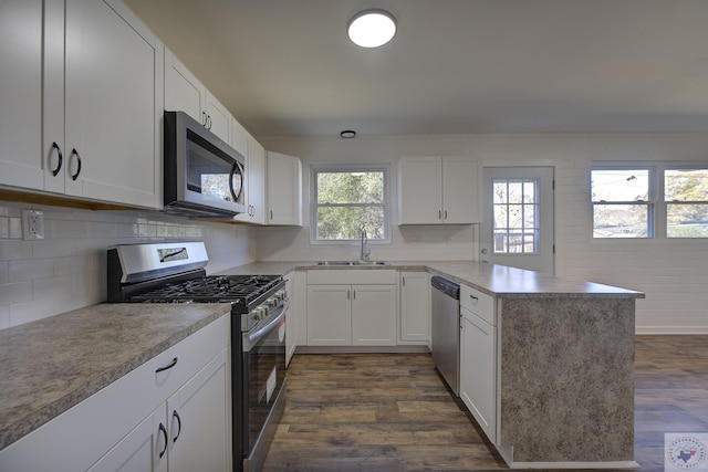 kitchen featuring tasteful backsplash, white cabinets, sink, stainless steel appliances, and dark hardwood / wood-style floors